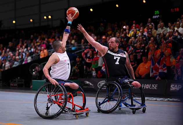 Two people in wheelchairs playing basketball